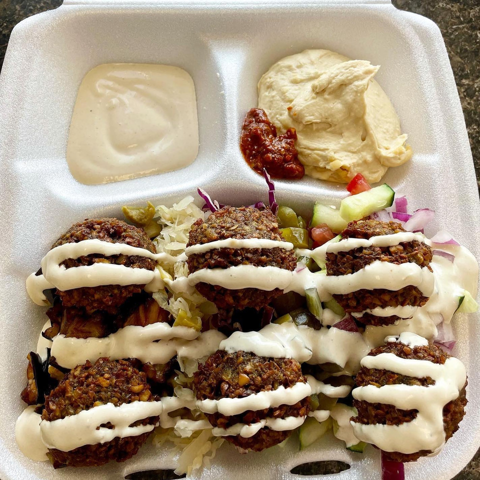 A kosher falafel platter from Mordy's Corner with hummus, tahini, and salad.